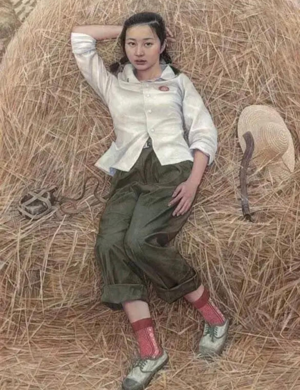 这张照片拍摄于上世纪70年代,一位女知青干完农活,正在一堆麦秸上休息