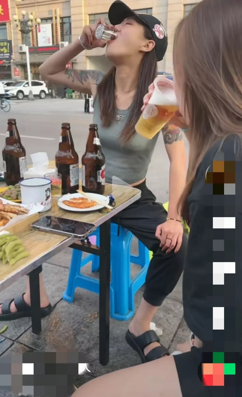 纹身女孩与短裤女孩两人聚餐喝啤酒,两人都倒满啤酒后