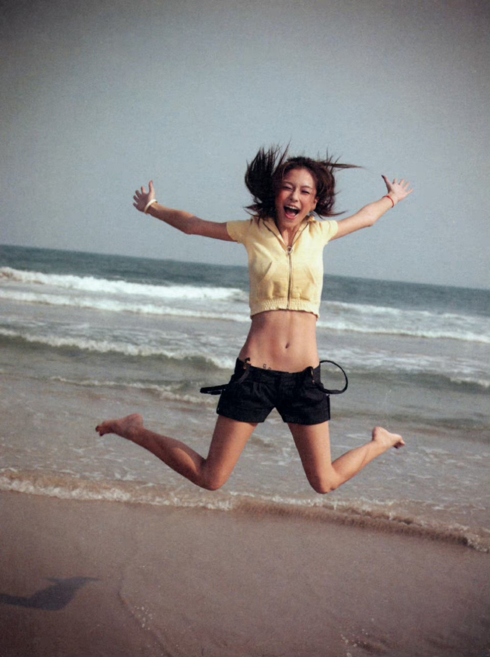 杨颖早期沙滩照,可以清晰的看到她的腹肌和马甲线,可能长时间在沙滩