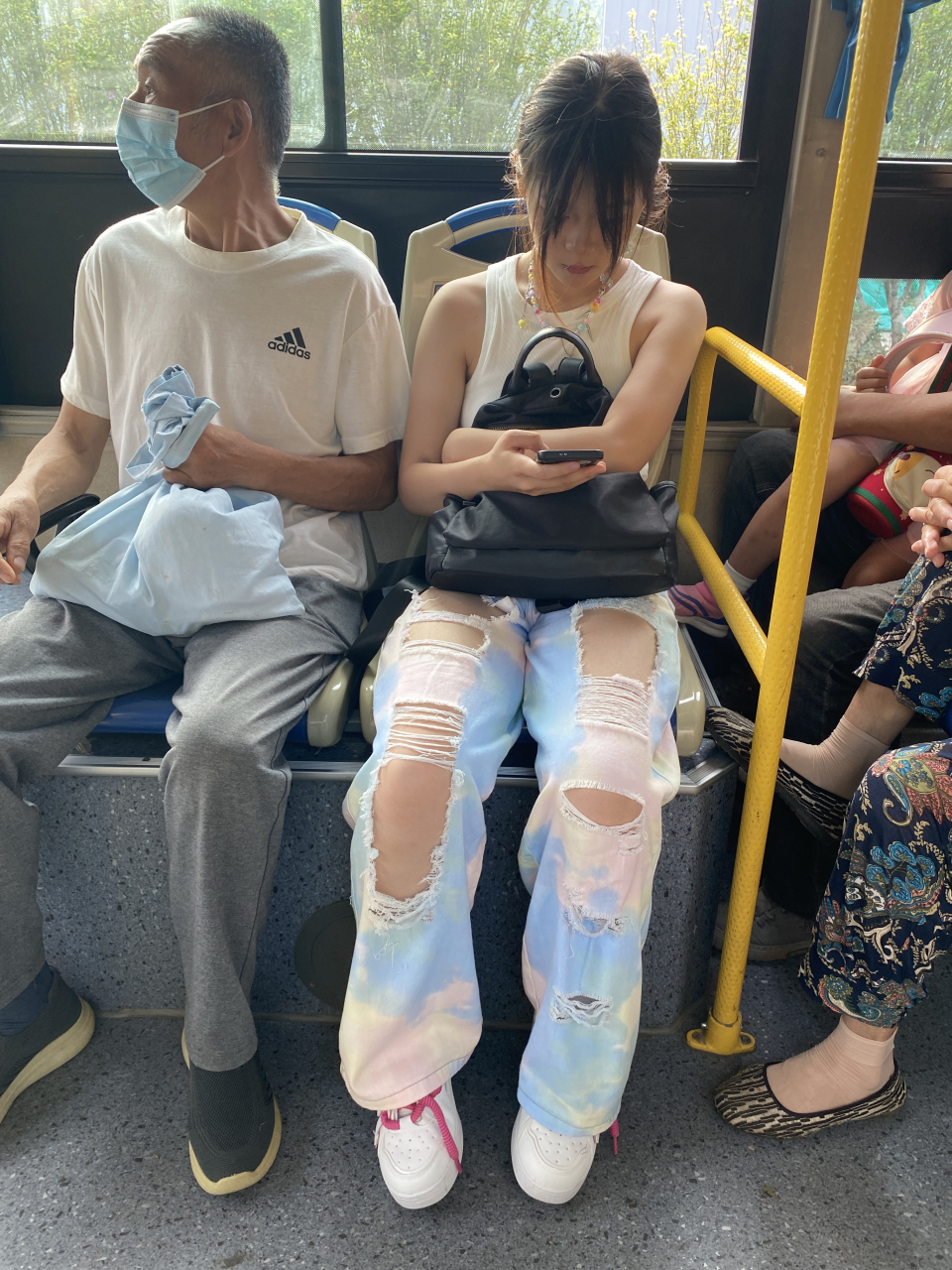 公交车上的小美女,穿的很是时髦,白色小背心搭配破洞牛仔裤,脚穿一双