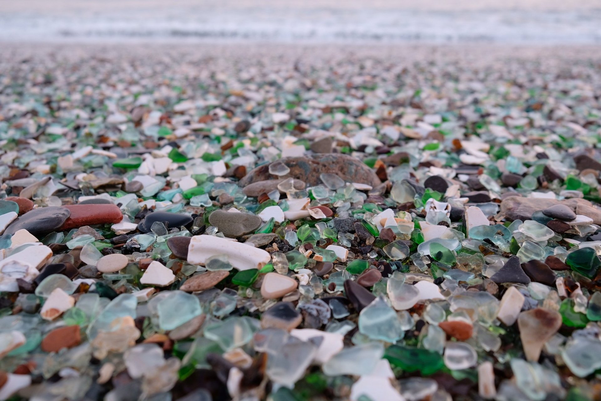 久而久之,碎了的酒瓶子被海水冲刷就成了今天的玻璃海滩,去之前看照片