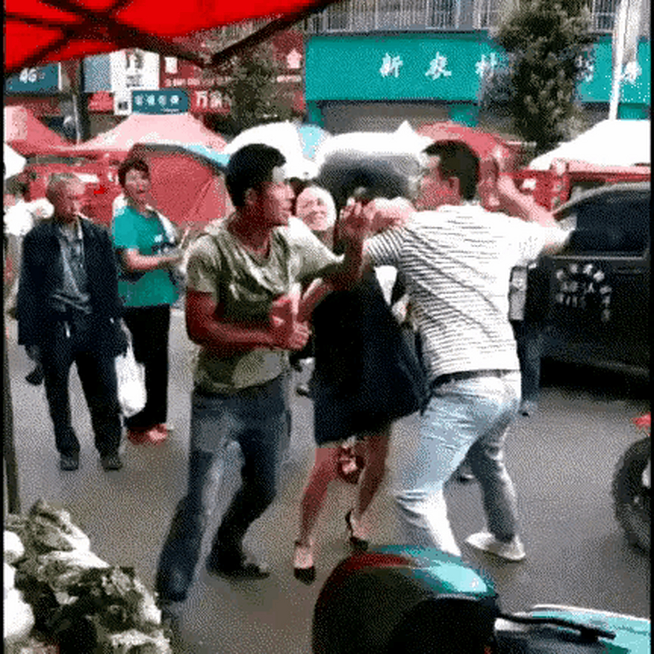 视频中某地两男子互殴打架时,其中一个高大威猛的男子手持