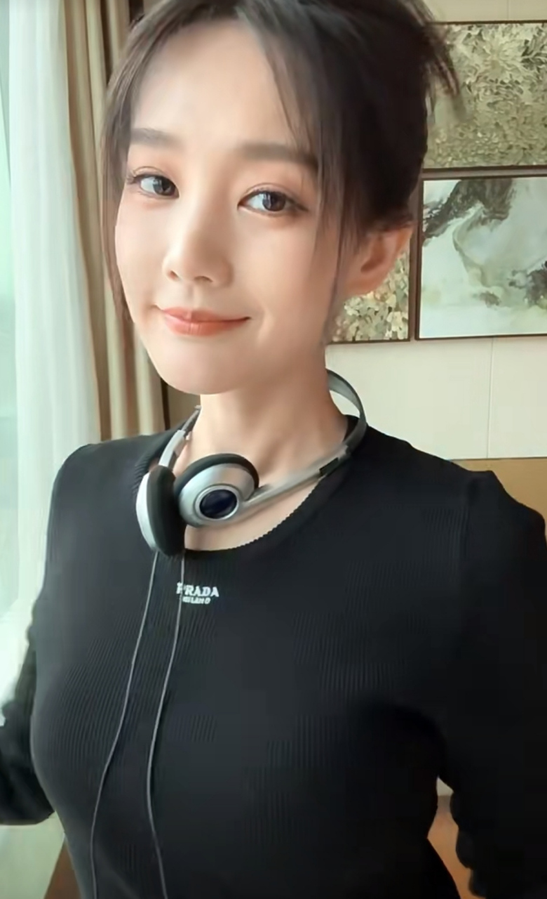 李一桐在窗户边美美自拍,手里拿着新的高跟鞋,黑色