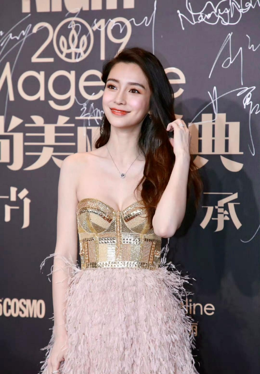 杨颖身穿一件金色的抹胸裙,在镜头前展现出凹凸有致的好身材