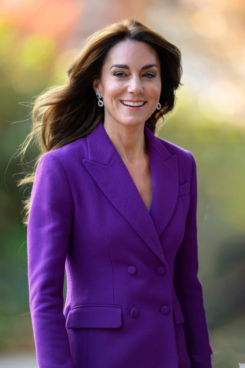 她戴着婆婆戴安娜王妃的蓝宝石耳环,身穿紫色西服发表演讲.