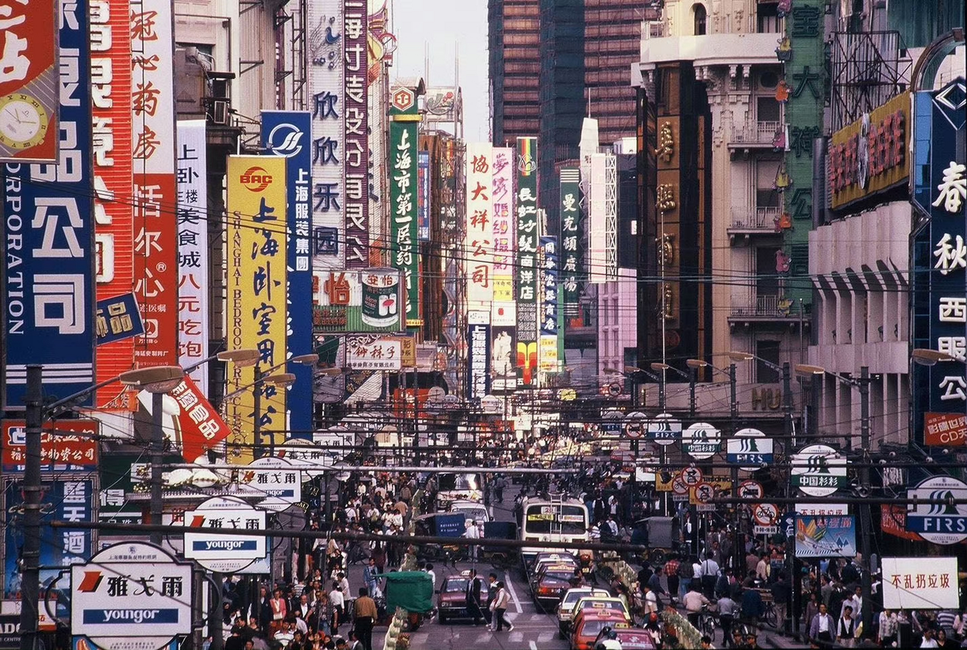 1999年的南京路,路上人群熙熙攘攘,到处都是生活气息,店铺照片陈列地