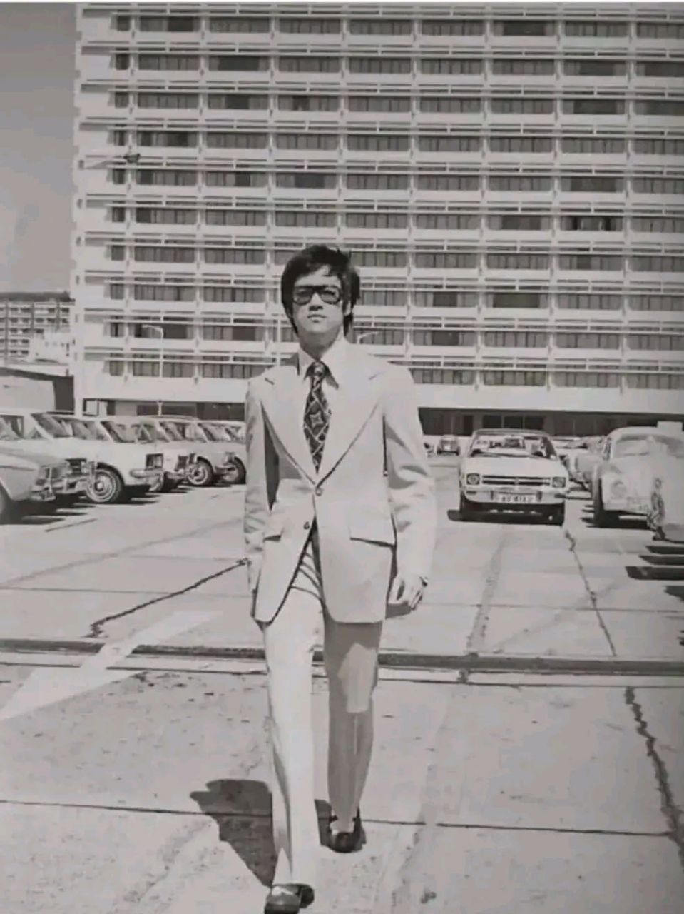 一身正装的武打巨星李小龙,照片中的李小龙一身笔挺的西装,戴着衣服
