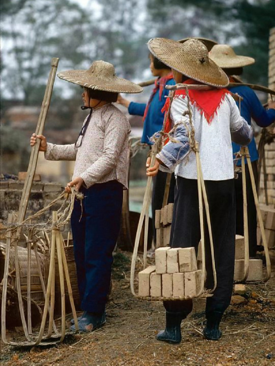 1979年,广东佛山的一个普通妇女,头上戴着草帽,脚下穿着皮靴,正挑着一