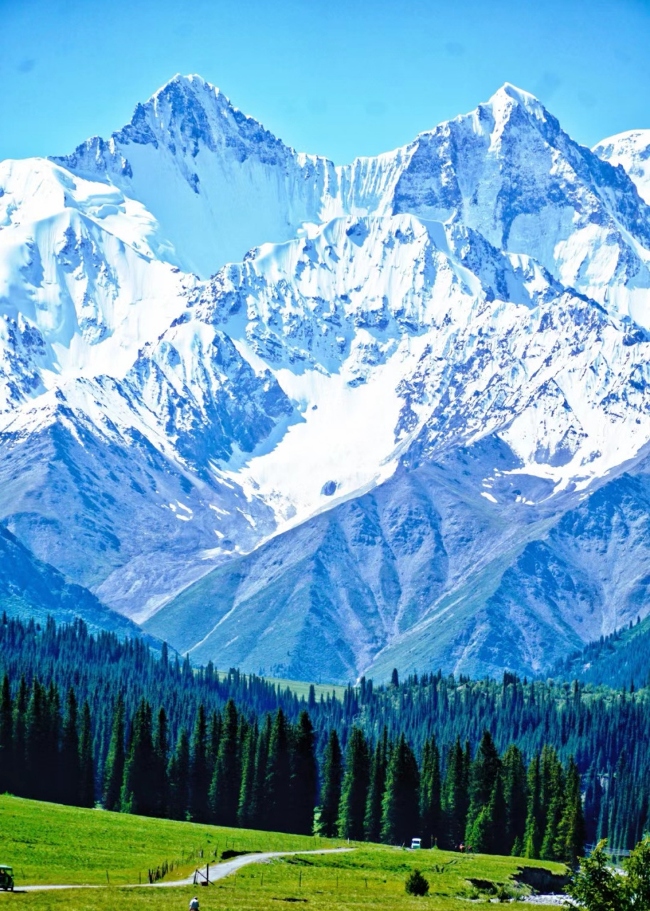 昭苏夏塔风景区,远处有皑皑白雪,蓝天白云如梦如幻,美不胜收.