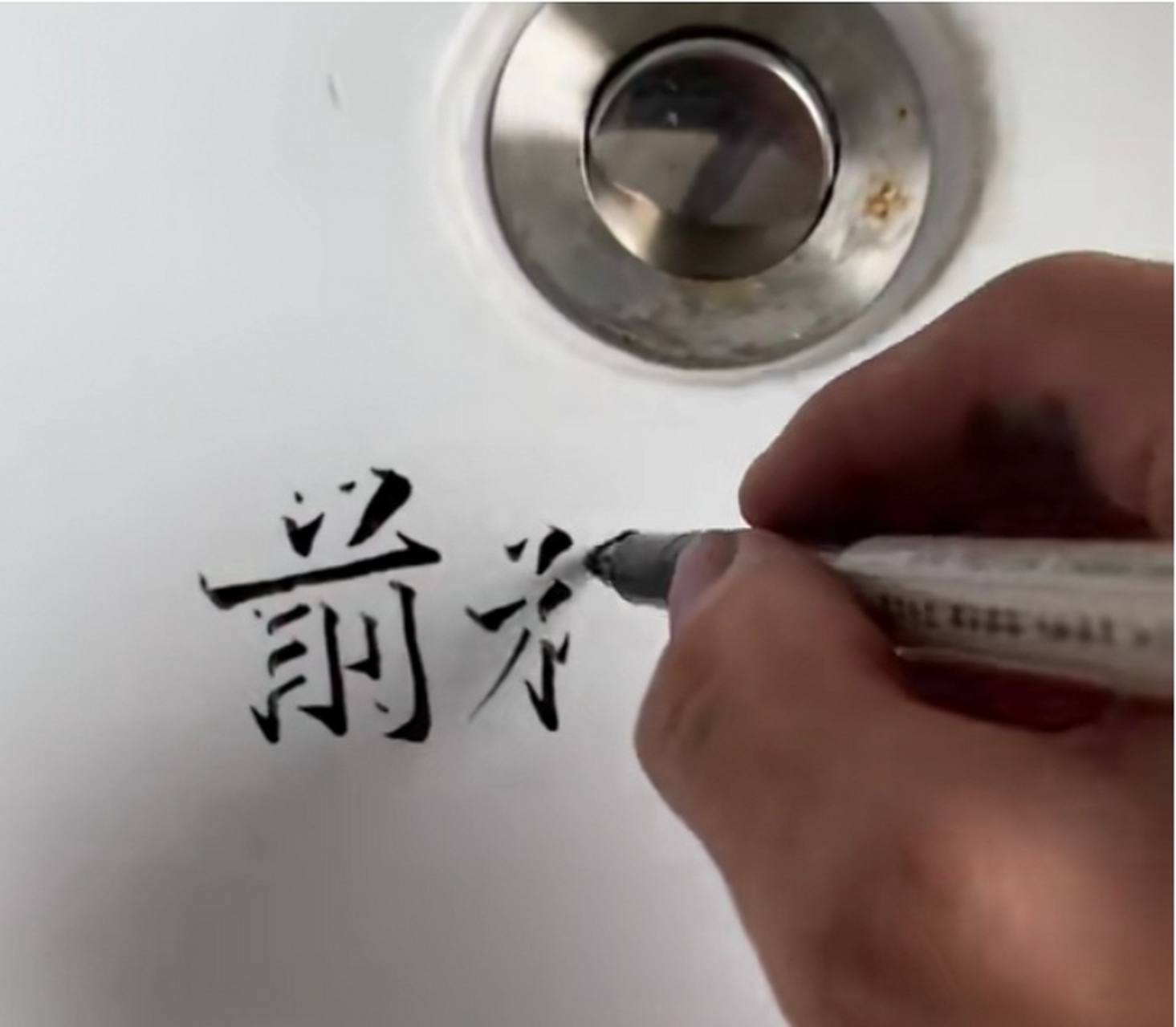 男子洗手池手写惊艳立体字 近日,广西南宁,男子在洗手池用黑色的笔写