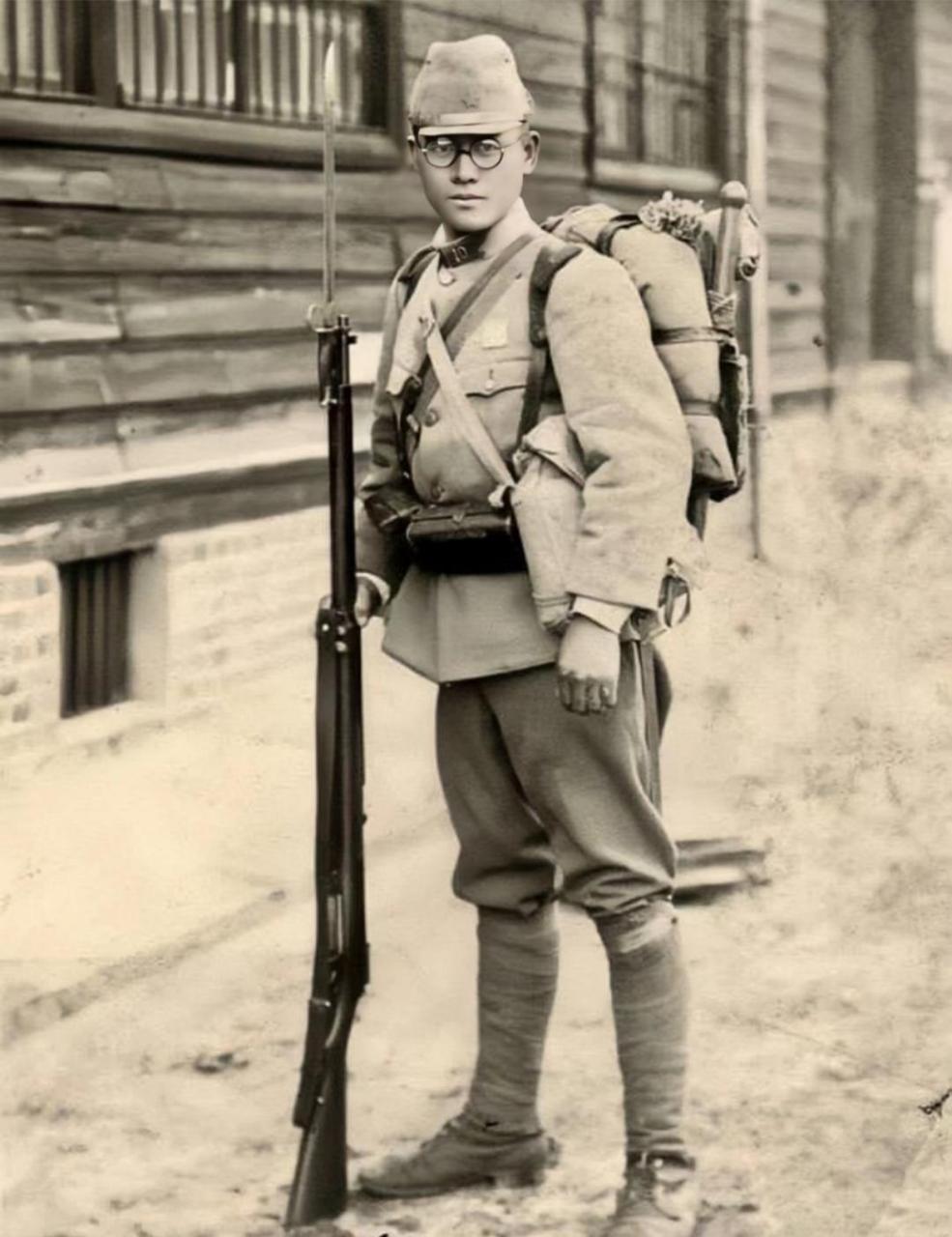 全副武装的日本士兵,他背着行囊,拿着带刺刀的枪,戴着眼镜,显然受到了