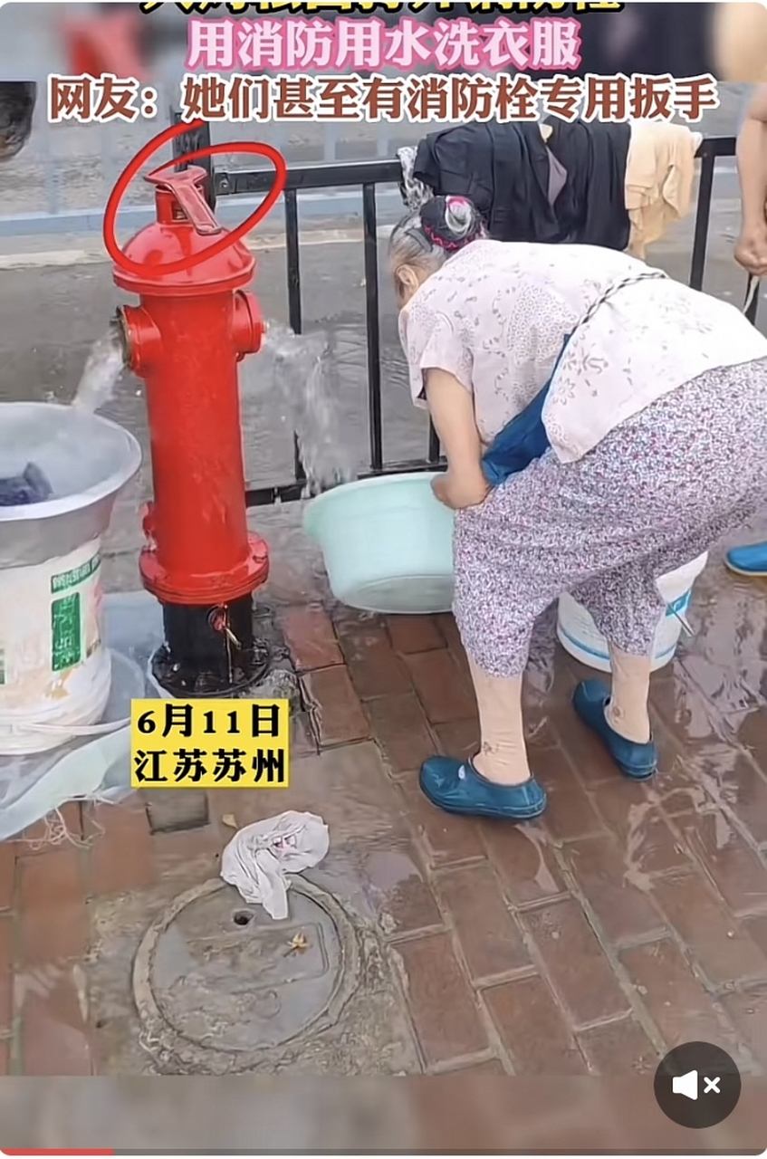 江苏苏州大妈们偷偷的打开街道旁消防栓,用消防用水洗衣服