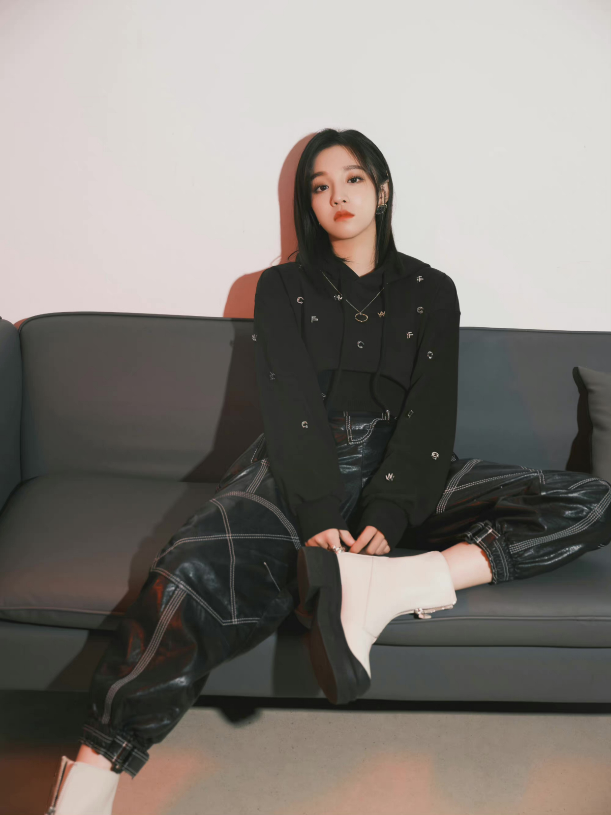 宋雨琦身穿黑色短款卫衣内搭背心,搭配同色系皮裤与白色中筒靴