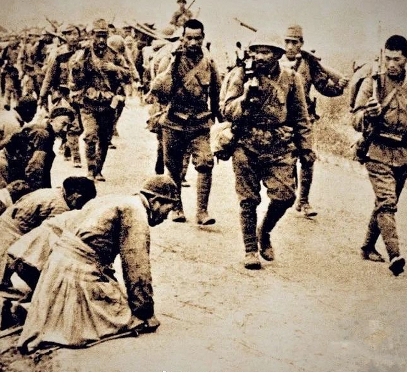 面对日军侵略,手无寸铁的百姓只能跪在路边祈求放过他们.