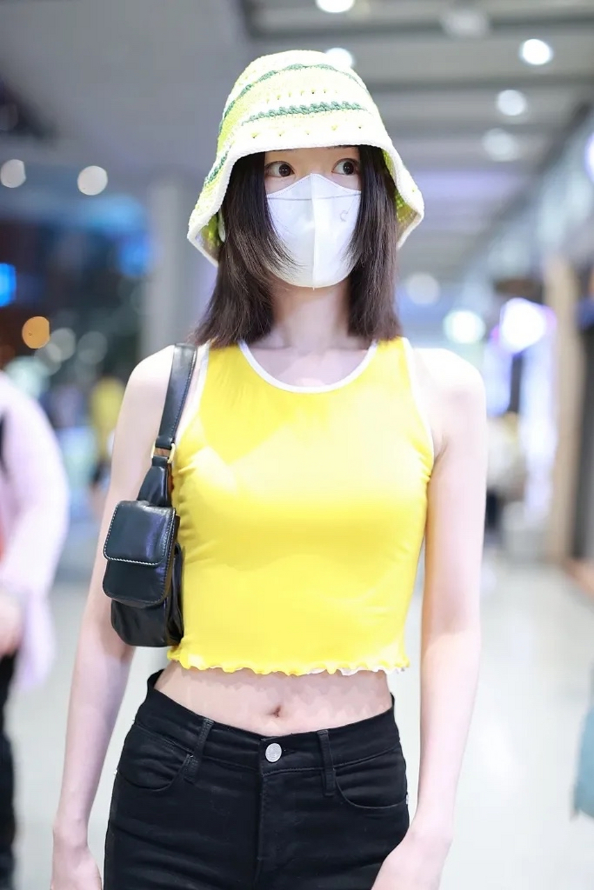 毛晓彤最新私服来了,她戴了一顶黄白条纹的针织帽子,穿一件黄色的露腰