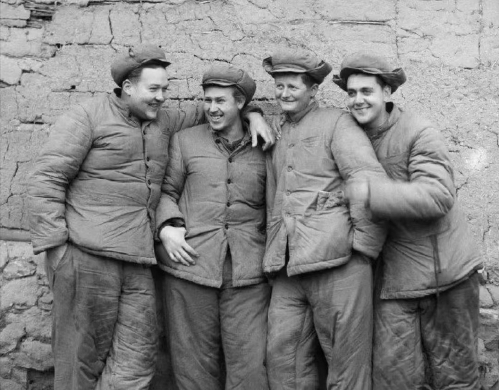 抗美援朝时期,几个被俘的美国大兵正靠在墙边,笑容满面,悠然自得.