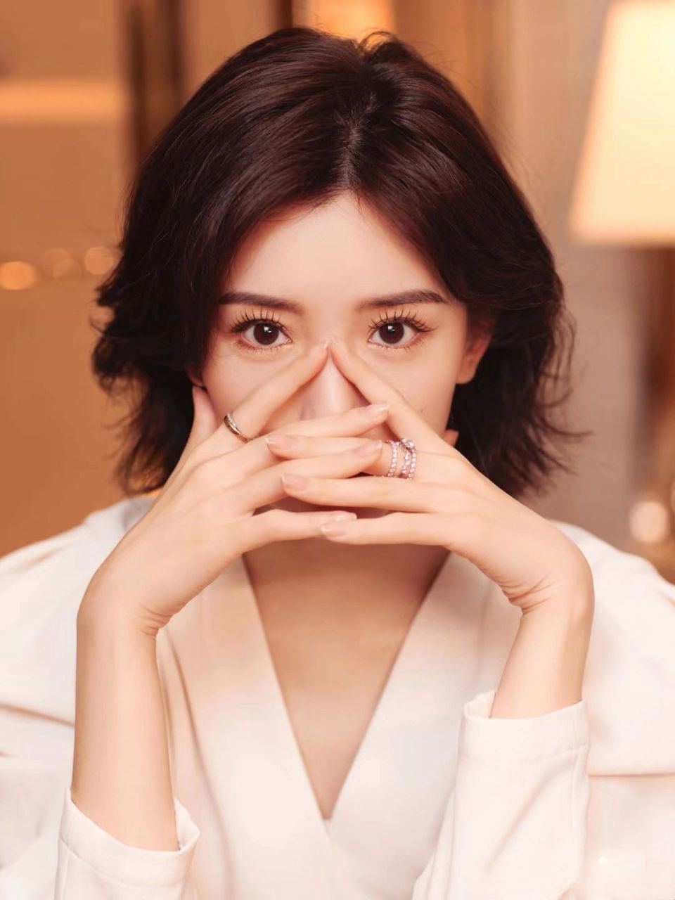 毛晓彤为代言秀戒指,穿白色v领连衣裙优雅显气质,高级感十足,尽显成熟