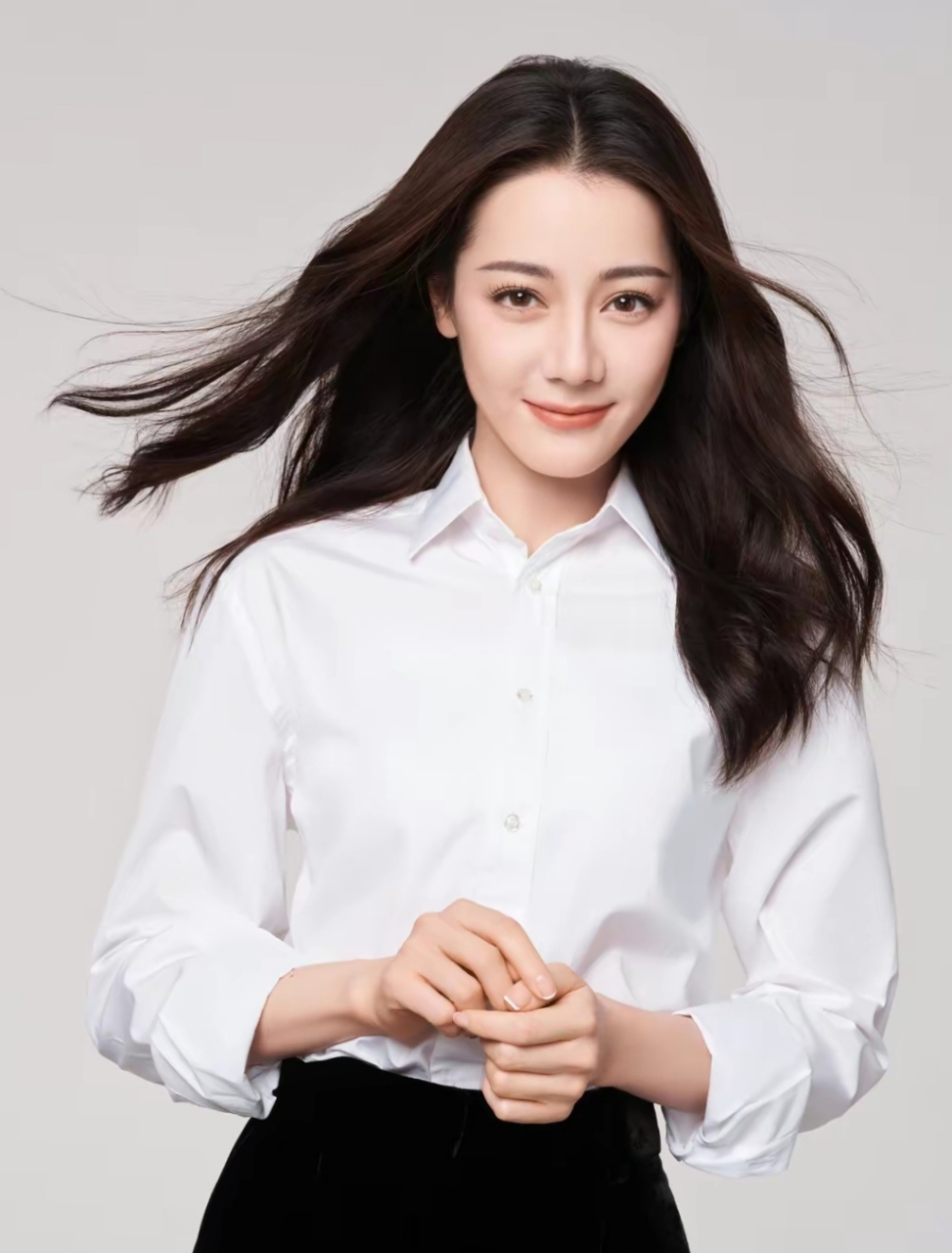 看迪丽热巴穿着白色衬衣,搭配黑色阔腿裤,显的身材苗条,长发飘逸,随性