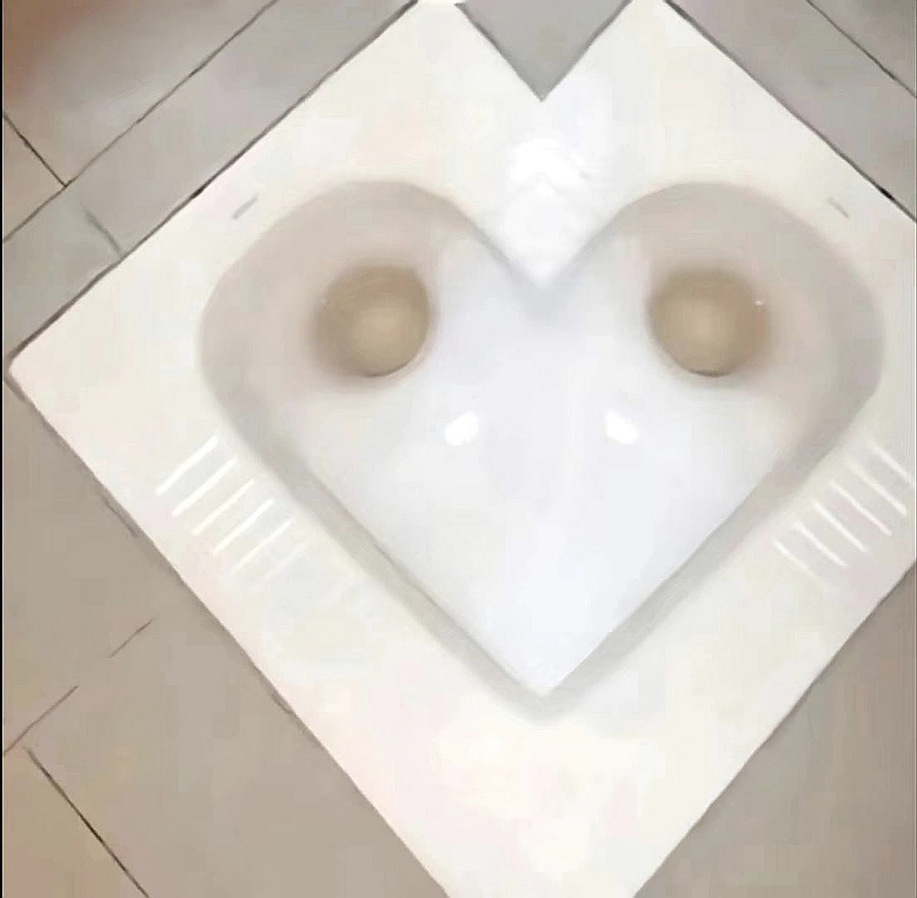 这个心形蹲厕也太有爱了吧?设计师的初衷是什么呢? 是想两个一起拉?