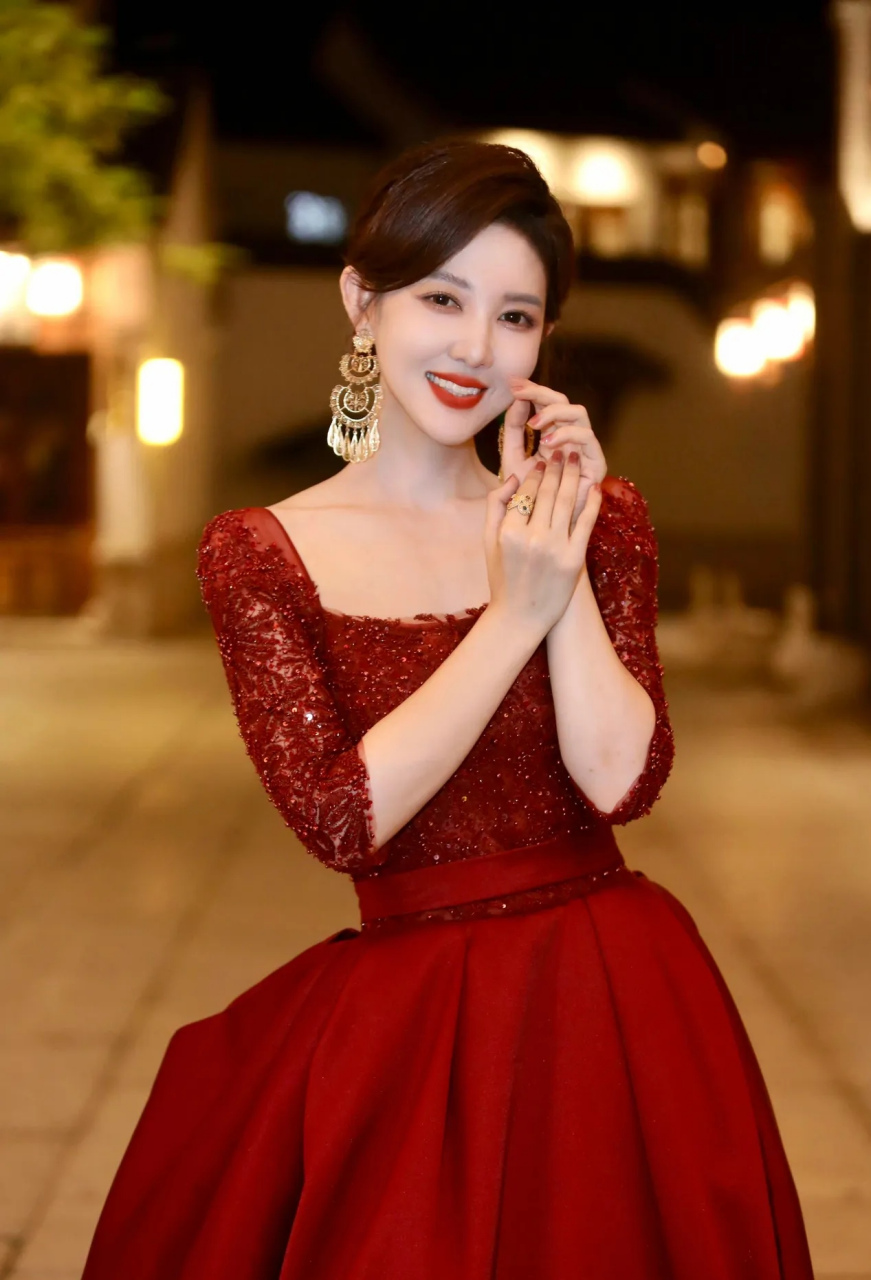 百度秋冬打卡挑战赛# 美女主持人郭玮,身着大红色蕾丝礼服,笑容灿烂