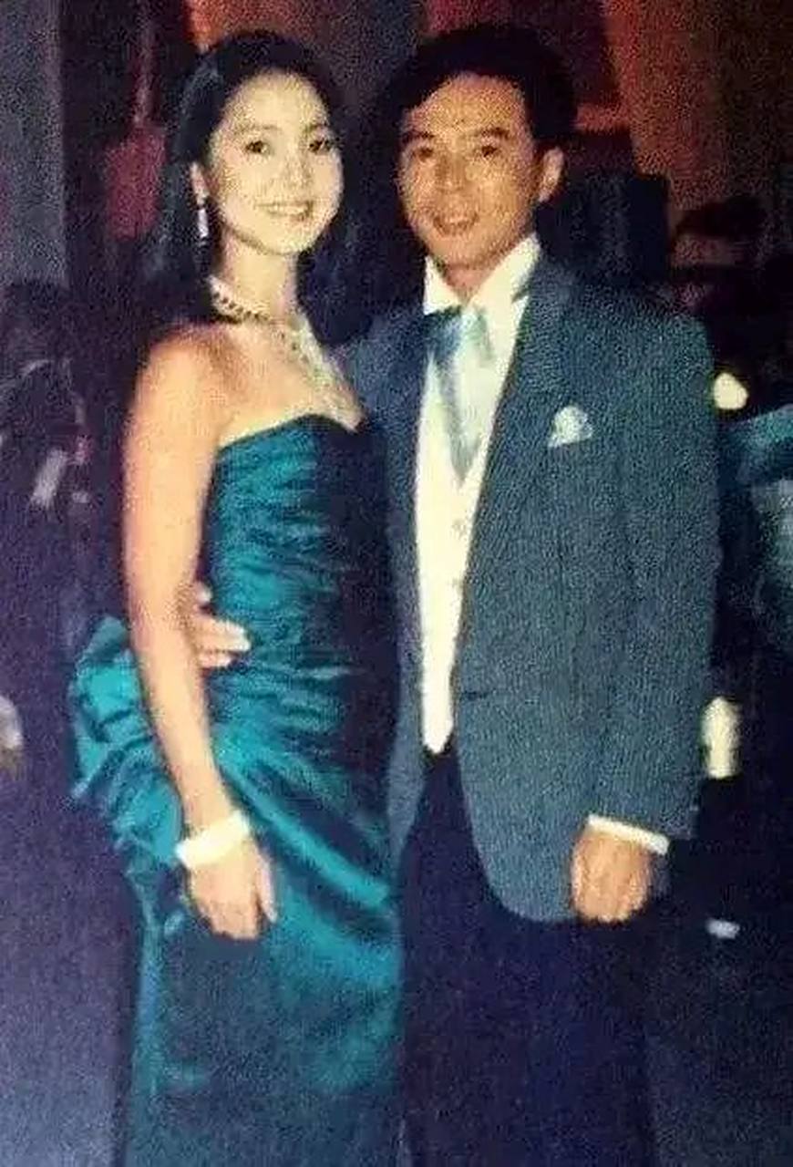 身穿一套西装,帅气的森进一搂着邓丽君的细腰,俩人面对镜头露出一丝