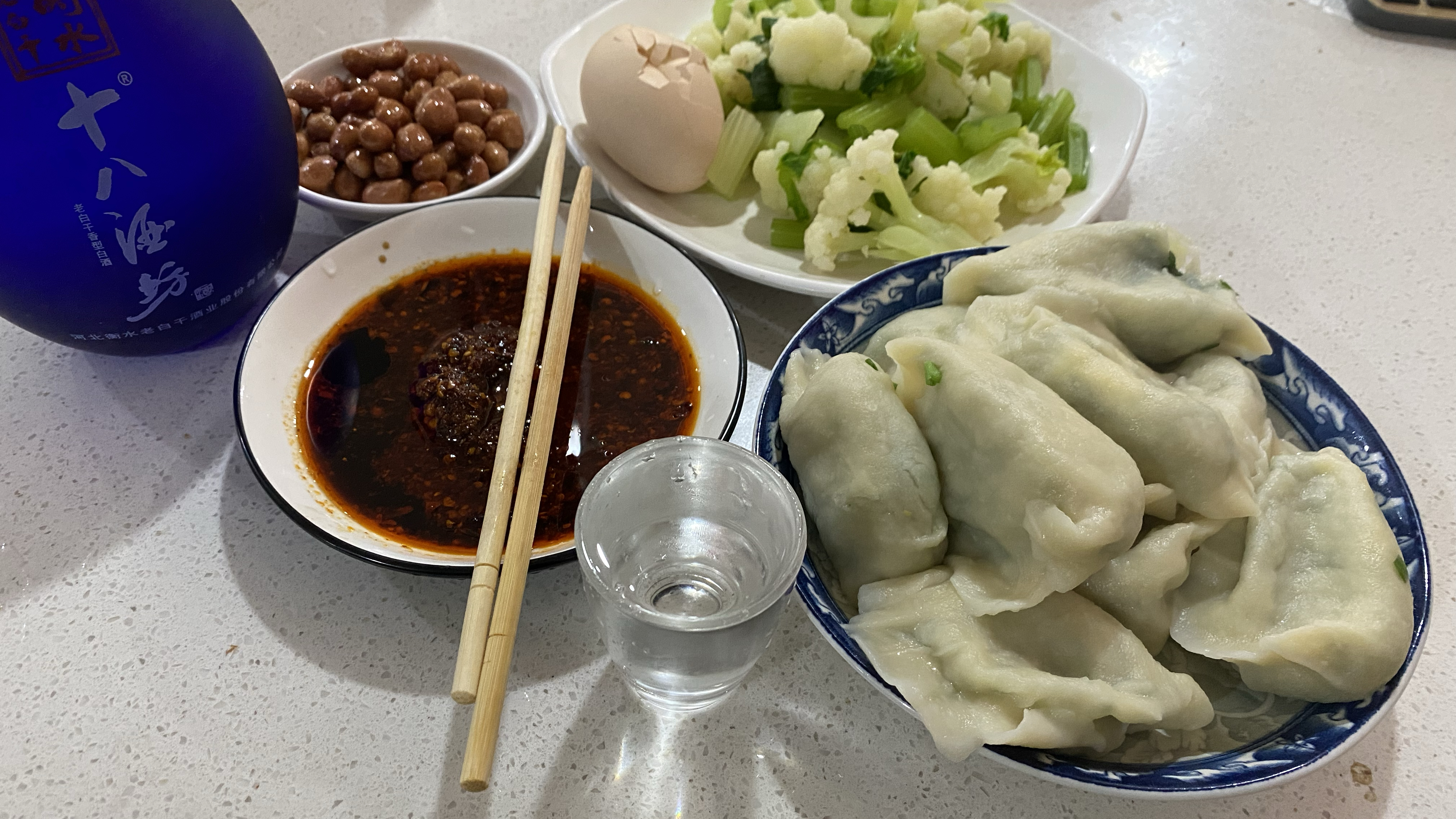 早上吃饺子,一碟花生米一盘凉菜,饺子蘸辣椒油,喝口小酒,得劲