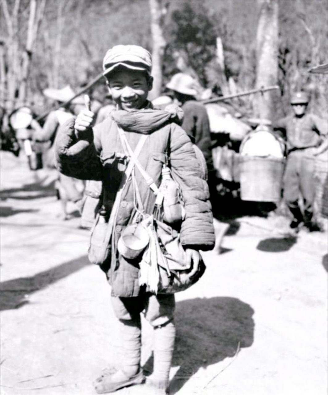 中国远征军里的娃娃兵,照片中的孩子身上穿着棉衣,脖子上挂着两个水壶