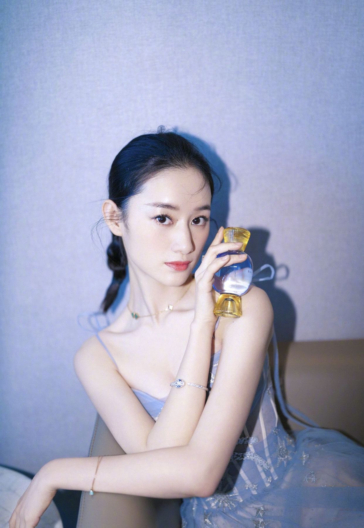 郭晓婷身着蔚蓝吊带纱质长裙出席品牌活动,手持鲜花艳丽点缀