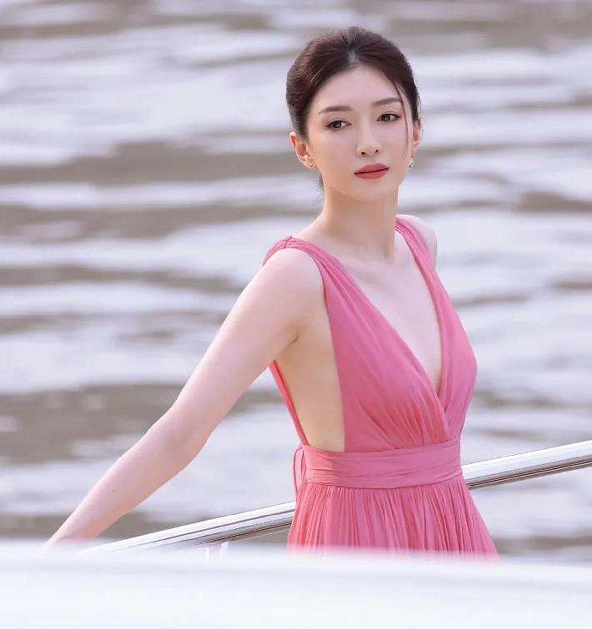 江疏影身穿玫红色长裙站在海边,展现出一种纯净而迷人的气质.