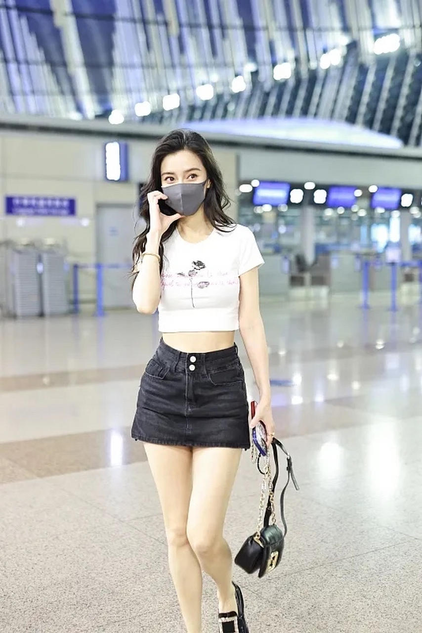 杨颖出发前往巴黎参加高定时装周,她穿了一件白色小圆领短袖露腰的t恤