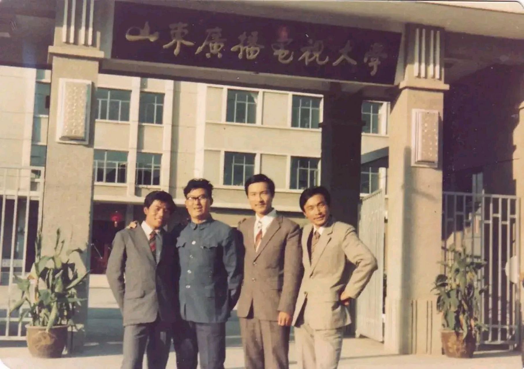 这张照片拍摄于1983年,济南市的山东广播电视大学校门口,四名同学的