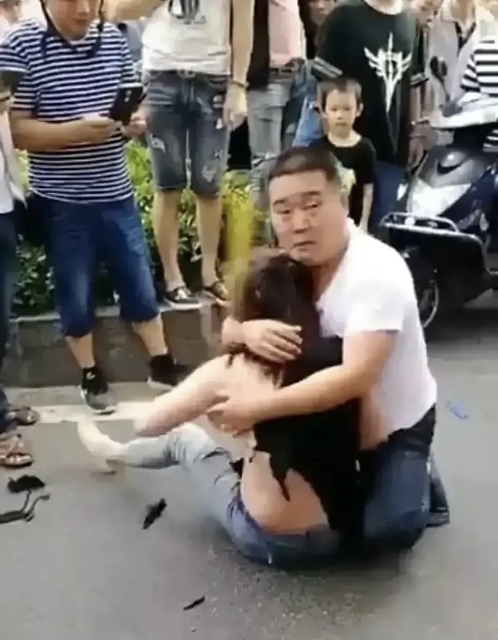 眼看小三衣服被扯破,为了保护小三,男子用自己宽厚的臂膀,将她紧紧护