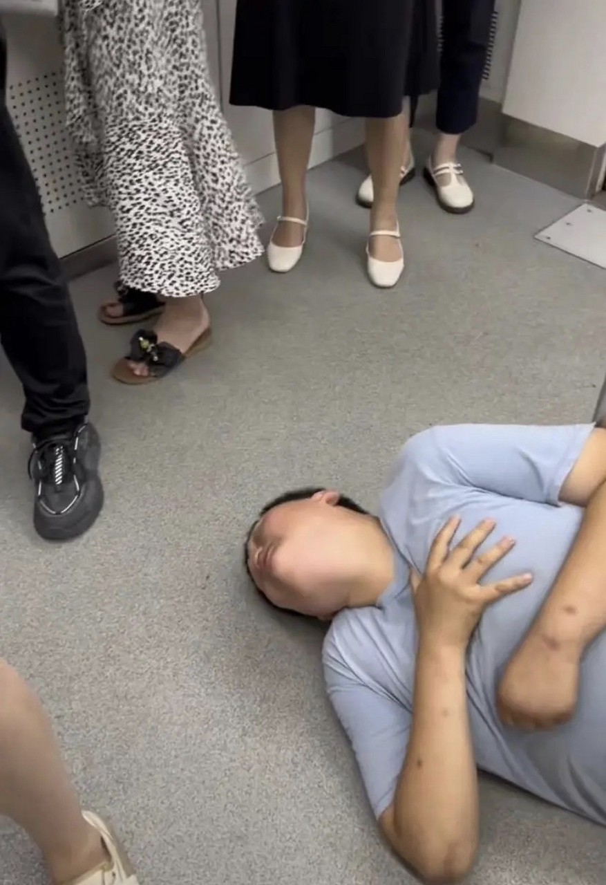 重庆,地铁车厢中,一名男孩长相的人突然倒地不起,用手捂着自己的胸口