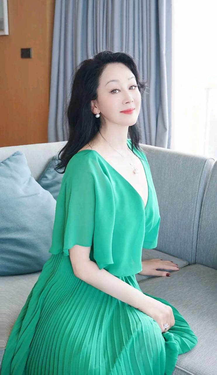 王姬在海边吹风,一袭绿色纱裙搭配白色高跟鞋,风情万