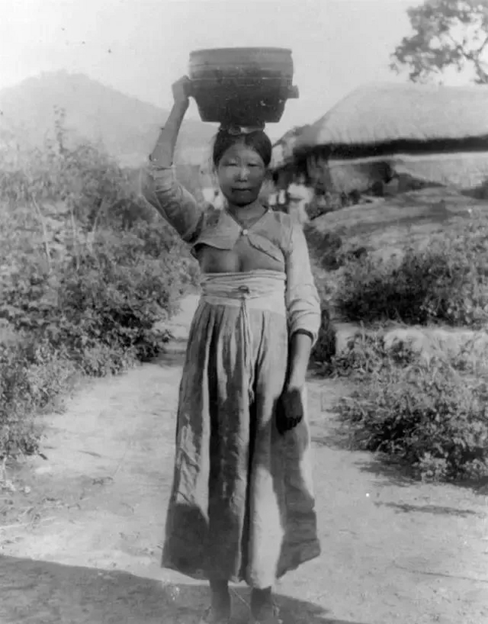二十世纪初的朝鲜半岛,头顶木桶的一名女子