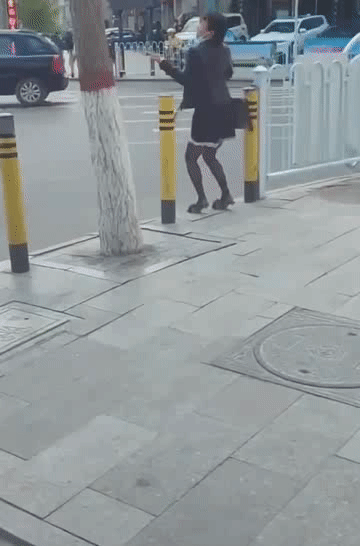 男子身穿黑丝短裙,脚踩高跟鞋,街头忘情热舞