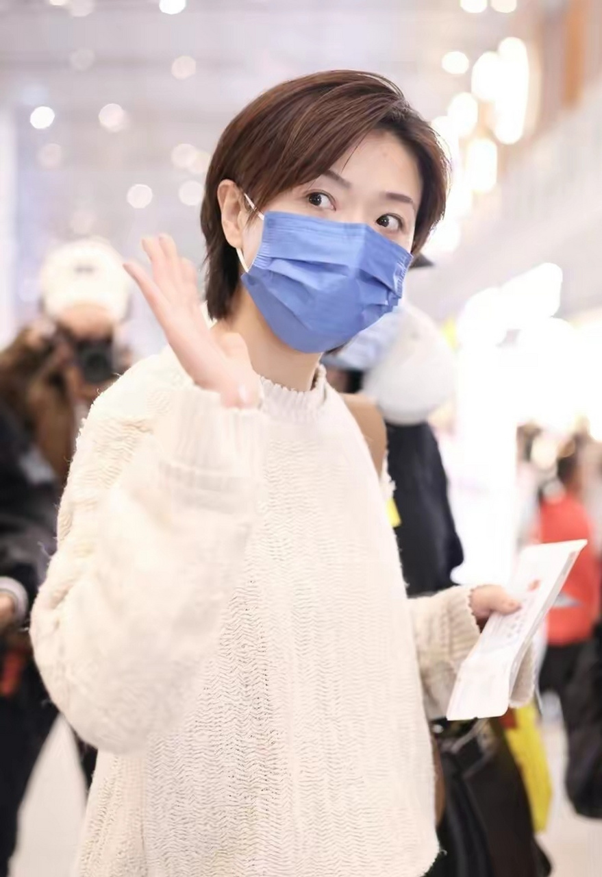 万茜北京机场街拍穿搭 身穿米白色针织衫,搭配灰色老爹西裤 肩上的