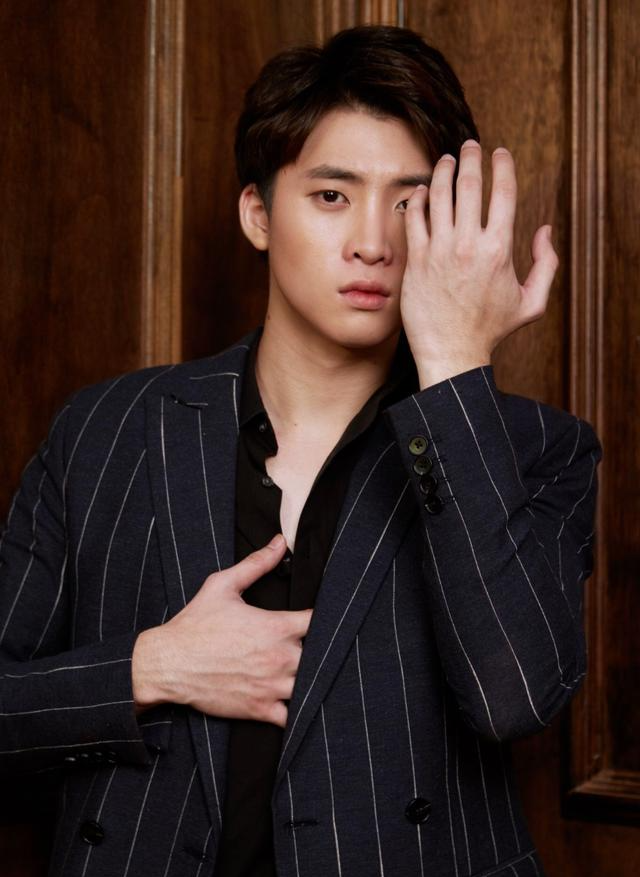 洪天逸笑容温暖,搭配黑西装优雅时尚,三七分刘海有少年气息