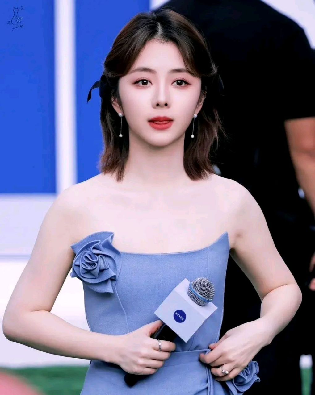 照片中,谭松韵身穿一袭蓝色抹胸花朵裙,展现出