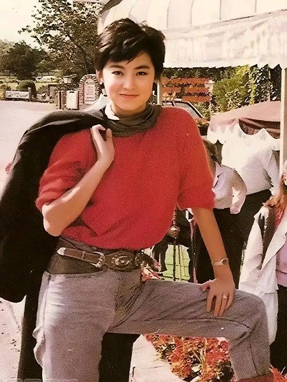 短发的林青霞看上去真的好有气场呀,穿着红色的t恤,一只脚放在石凳