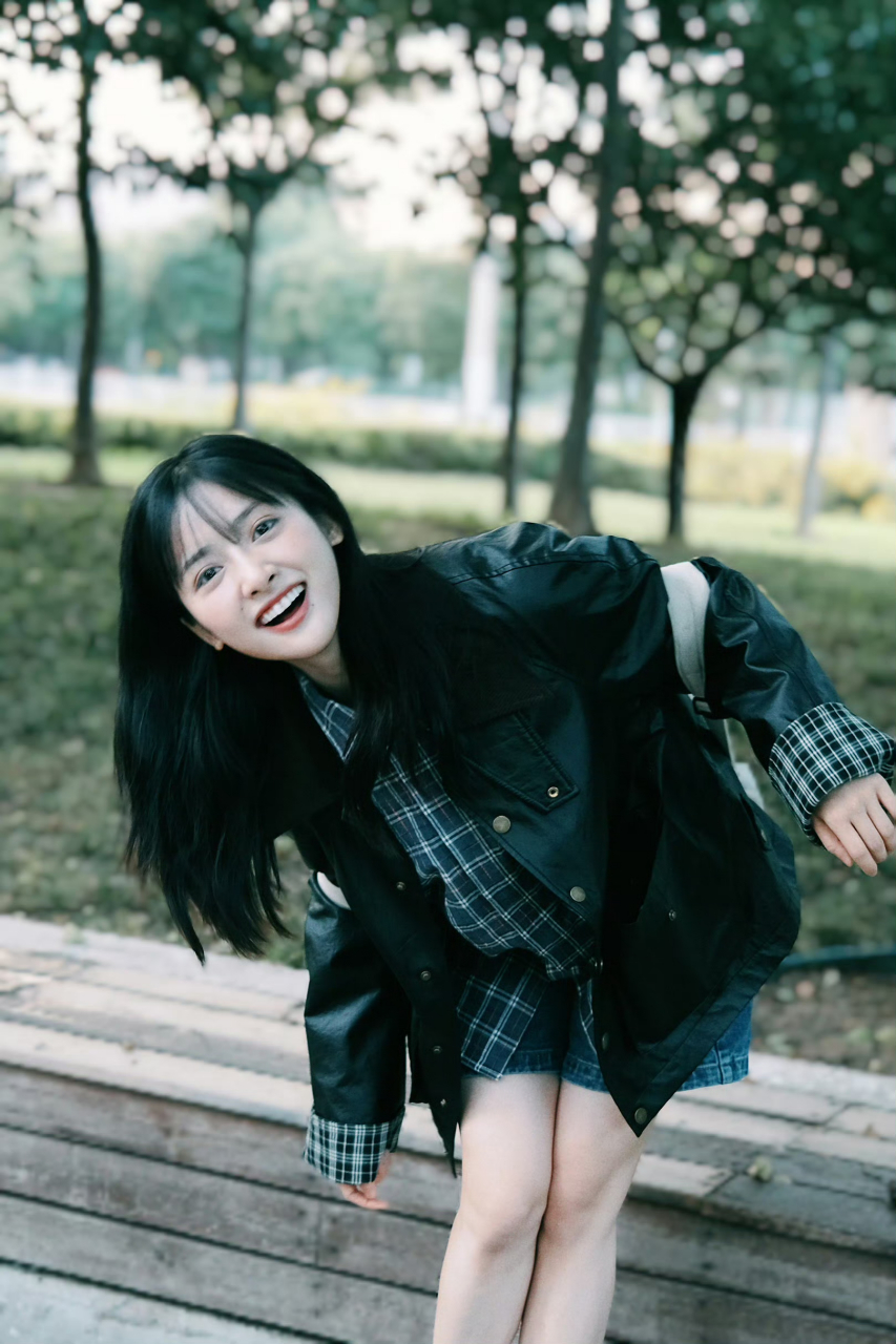 沈月,她穿格子衬衫黑色外套化身森系少女,梳齐刘海短发双眸灵动,对镜