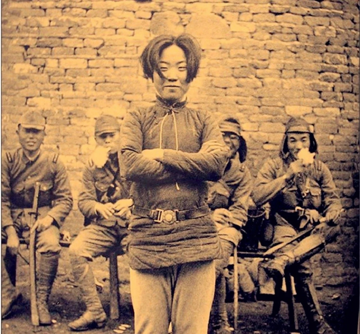 她站在一群日本鬼子兵中间,斜侧着身,双手交叉环胸,昂首微笑的.