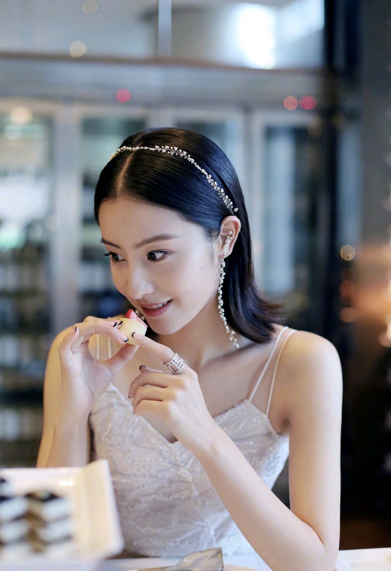 毛晓慧身穿白色吊带裙,身材纤细高挑,少女感十足