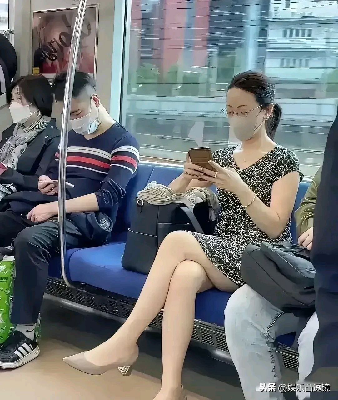 地铁上,一位打扮精致的女子正在看手机.