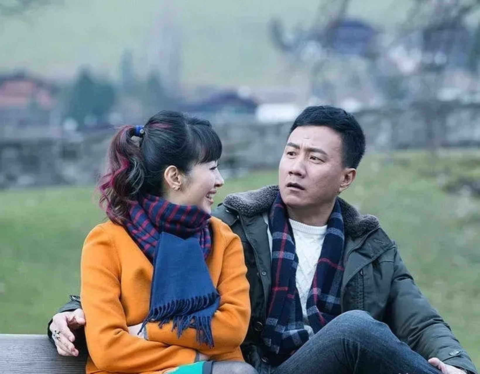 胡军穿军绿色休闲派克服,留着精干的短发,搭配蓝色格纹围巾,干练