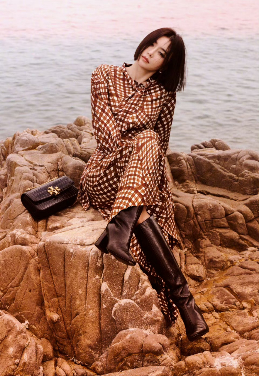 在海边,吹着秋风,秦岚身穿一套格子款的衬衫连衣裙搭配高筒高跟靴拍照