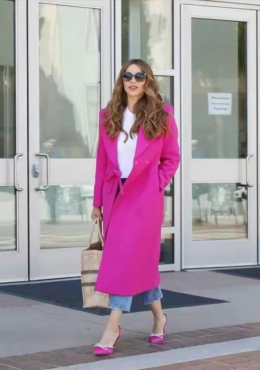 索菲娅维加拉身穿玫红色大衣,搭配蓝色牛仔裤,优雅!