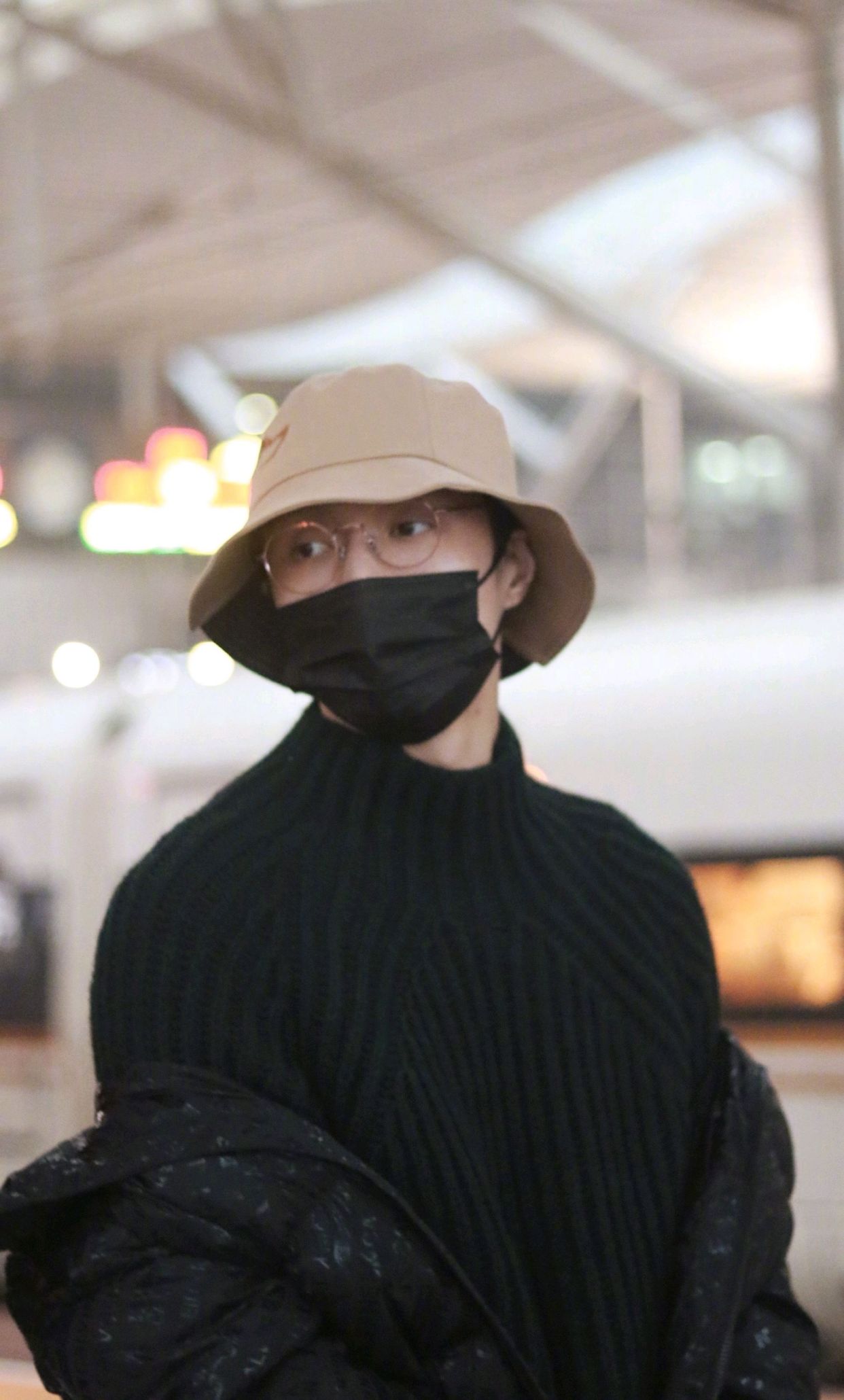 张艺兴行程饭拍图,身着深色毛衣配亮闪羽绒服,休闲舒适男友穿搭