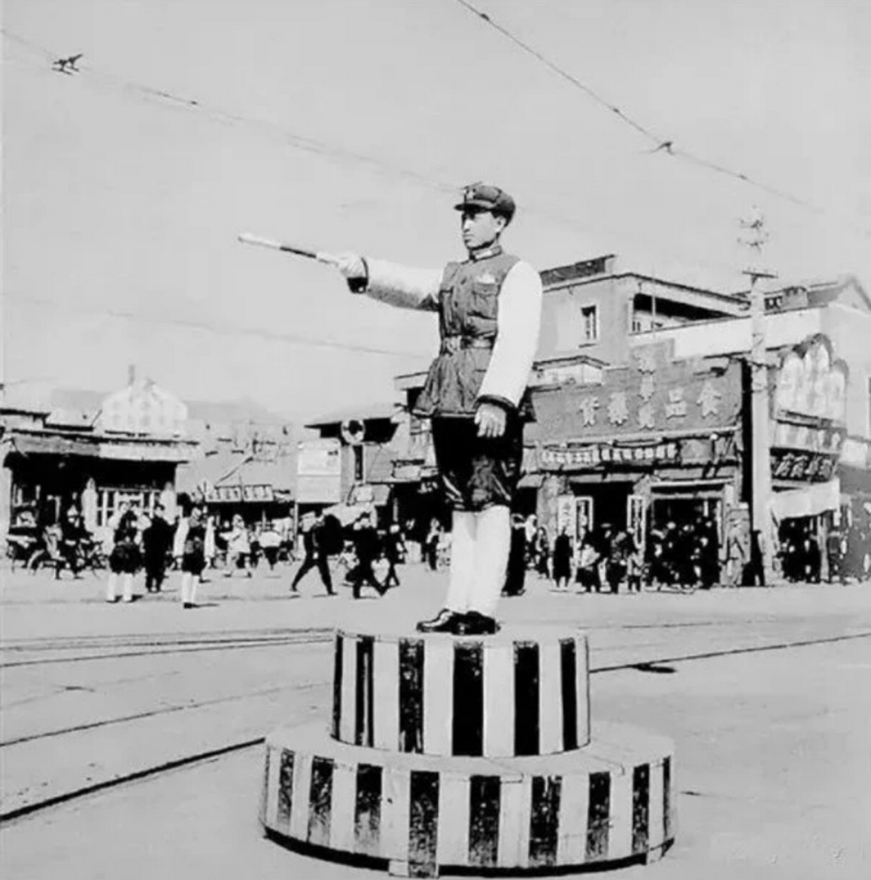 1954年,北京西单老照片,一个十字路口,交警拿着指挥棒正在指挥交通,他