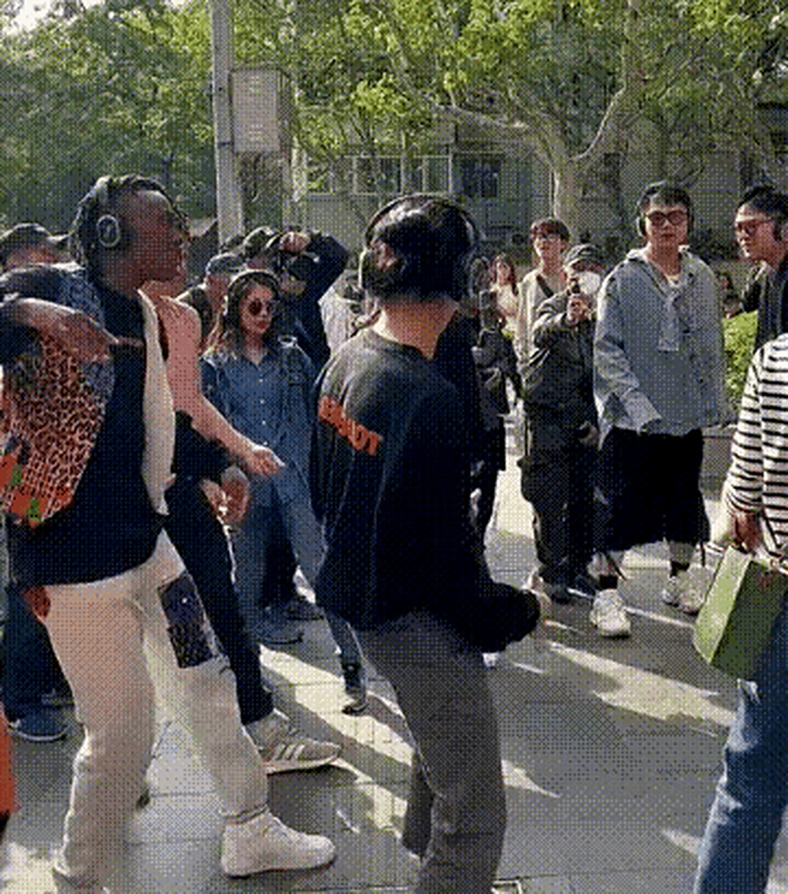 近日上海街头,一名黑人小伙带着一群中国年轻人在街上边走边跳舞